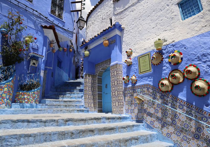 Blue steps decorated with brass pots and colourful tiles