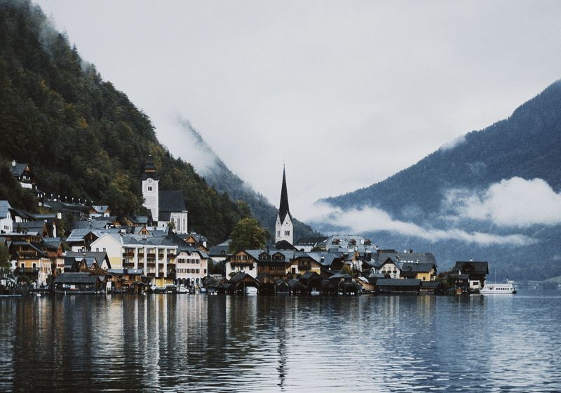 Hallstatt village and church on the lake under misty mountains