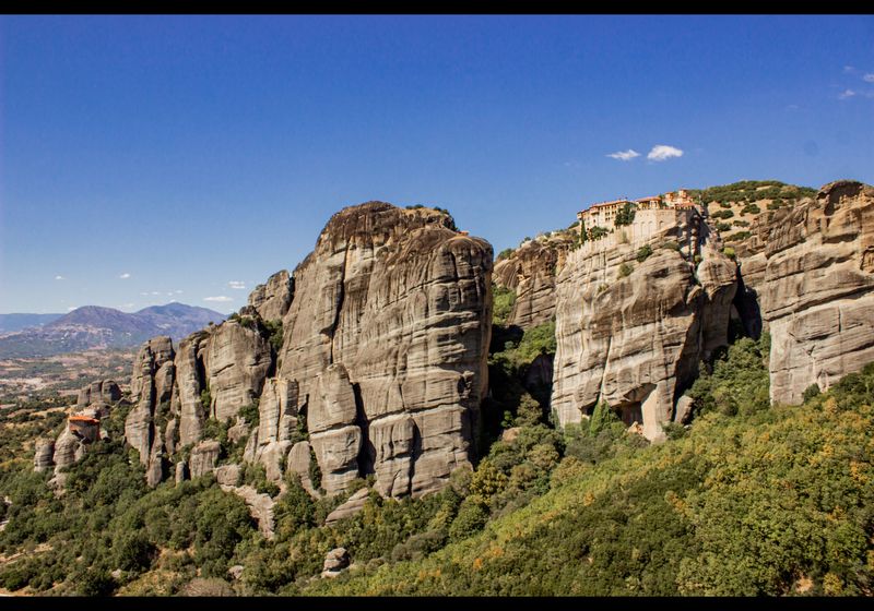Giant sandstone pillars of Meteora under a blue sky