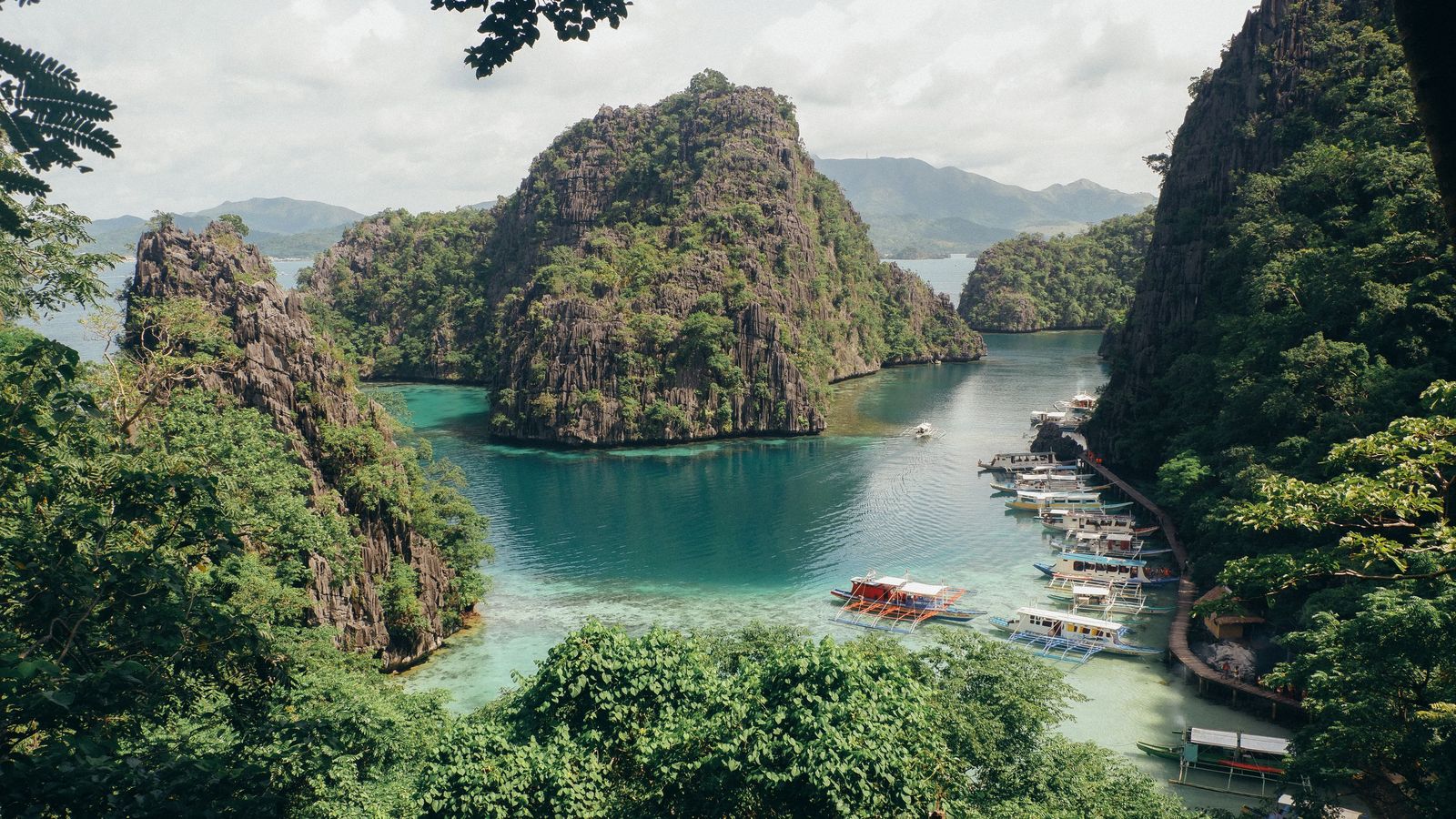 Turquoise lagoon between green limestone cliffs in Coron, Palawan