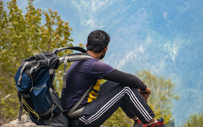 A hiker resting alone on a remote mountainside